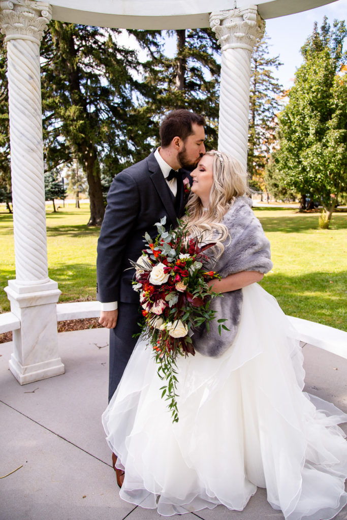 couple kissing with bouquet Elm Hurst wedding photography by london ontario photographer Woodgate Photography