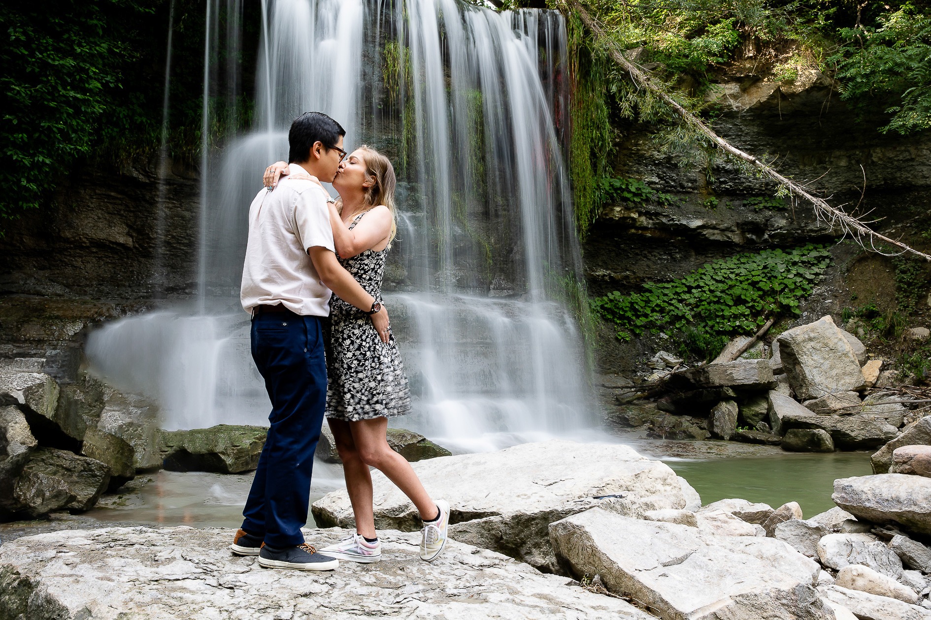Engagement Photography rock glen waterfalls with long exposure and couple kissing