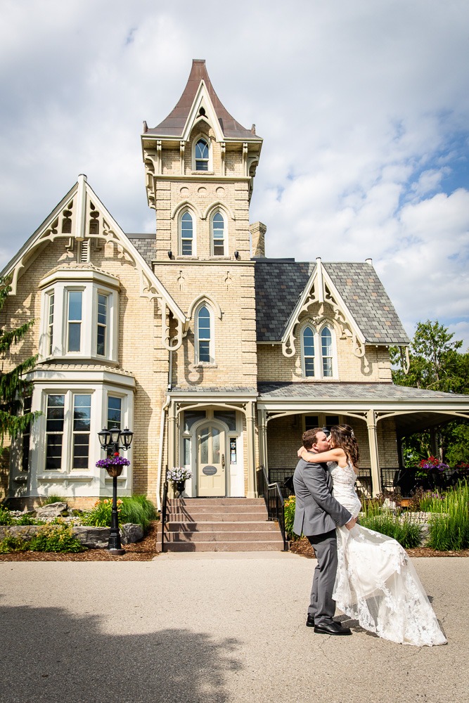 groom lifts bride in front of the elmhurst inn wedding photography